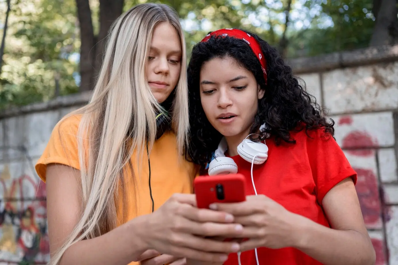 Plano medio de chicas mirando un teléfono.